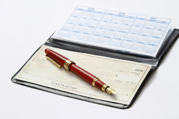 An open checkbook and a ballpen isolated on white