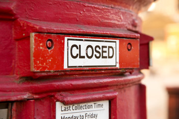 a shut red british letter box.