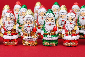 gr&uuml;ne, gelbe,rote Schoko Nikol&auml;use roter Hintergr.