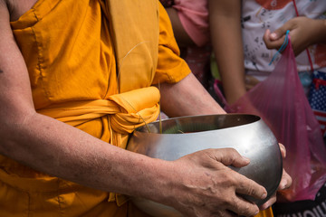 Buddhist monks are given food offering from people for End of Bu