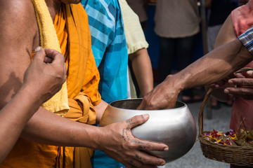 Buddhist monks are given food offering from people for End of Bu
