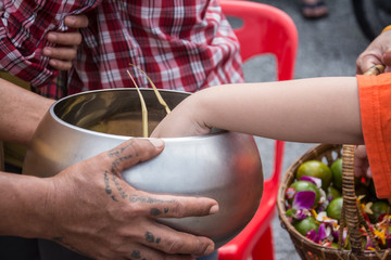 Buddhist monks are given food offering from people for End of Bu