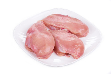 Raw chicken fillets on the plate.