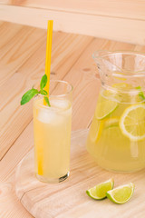 Pitcher full of lemonade on wooden table.