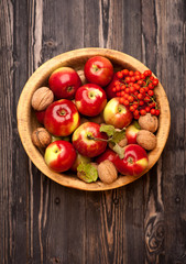 Apples and nuts in wooden bowl