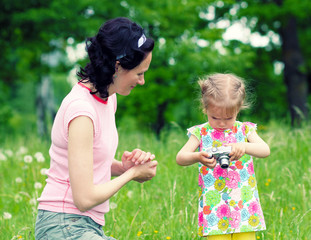 Obraz premium little girl child to learn to photograph with his mother