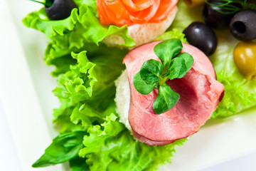 Cold snack with  ham,  salmon and olives