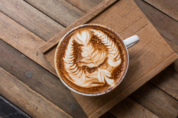 Cup of hot latte art coffee on wooden table