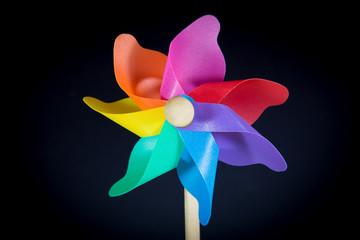 a beautiful colored pinwheel spinning faster in the wind