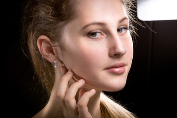 portrait of blonde woman against black background and studio fla