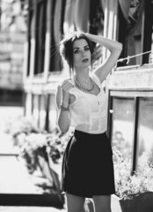 Monochrome portrait of slim woman in skirt on street