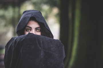 beautiful dark vampire woman with black mantle and hood