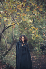 beautiful dark vampire woman with black mantle and hood