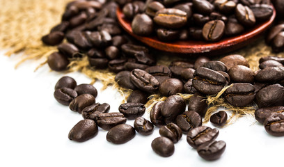 coffee beans on sacking and wood spoon, white background