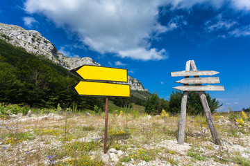 signposts on crossroad at mountain and forest