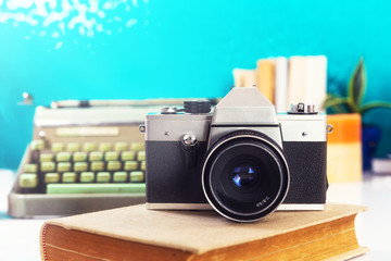 Analog camera, and typewriter and books in background.