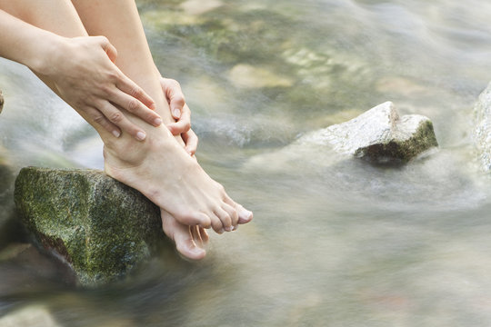Womans feet in a forest creek