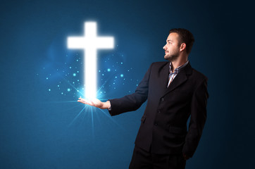 Glowing cross in the hand of a businessman