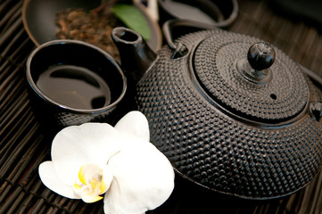 Obraz na płótnie Canvas Black iron asian teapot with orchid