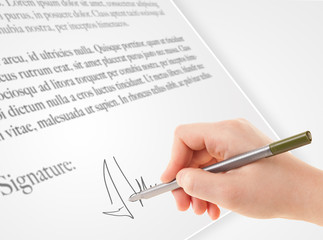 Hand writing personal signature on a paper form
