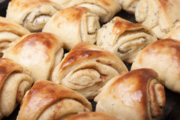 Buns from yeast dough with cinnamon and poppy twisted shell.