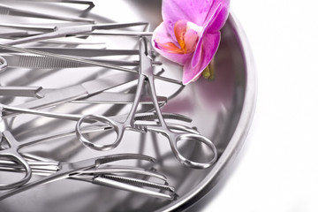 surgical instruments orchid on white with orchid