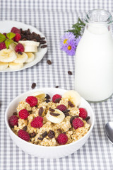 granola with fruits and bottle of fresh milk