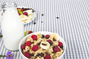granola with fruits and bottle of fresh milk