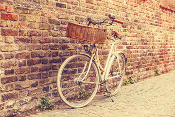 Fototapeta na wymiar White bike near brick wall