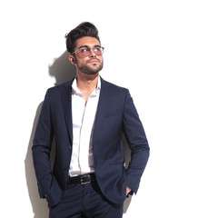 Attractive business man leaning on a white wall