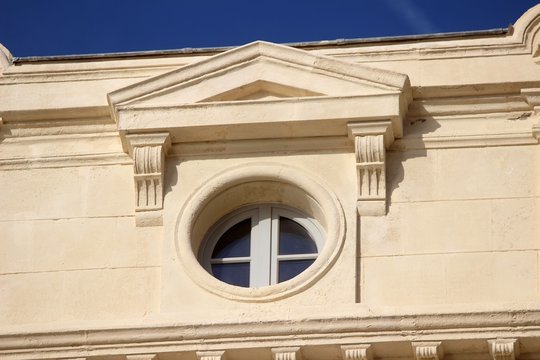 Oeil de boeuf surmont&eacute; d'un fronton triangulaire