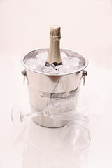 Champagne bottle in cooler and two champagne glasses