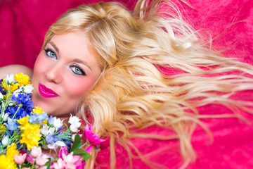 Obraz na płótnie Canvas Blonde Frau mit blauen Augen und Blumen