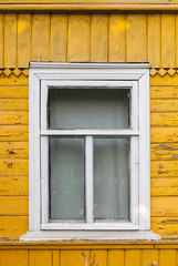 Russian rural house fragment, yellow wall and white window