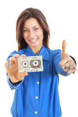 Beautiful woman holding audio tape cassette showing thumbs up