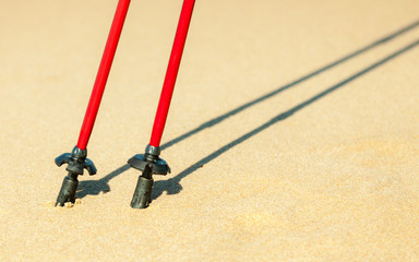 Nordic walking. Red sticks on the sandy beach