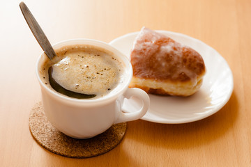 Beverage and sweet food. Cup of coffee and bun.
