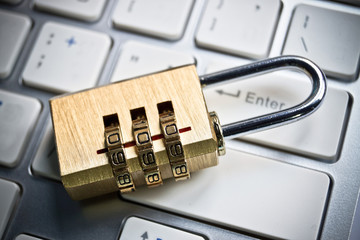 metal security lock with password on computer keyboard