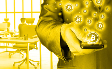 Hand with mobile smart phone and bitcoin symbol