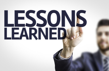 Business man pointing the text: Lessons Learned