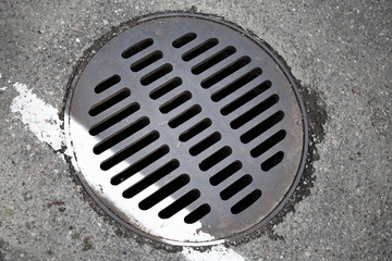Round hatch and white dividing line on urban asphalt road