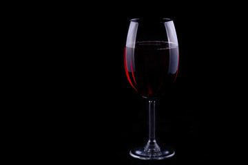 Fototapeta na wymiar Red wine glass on the black background