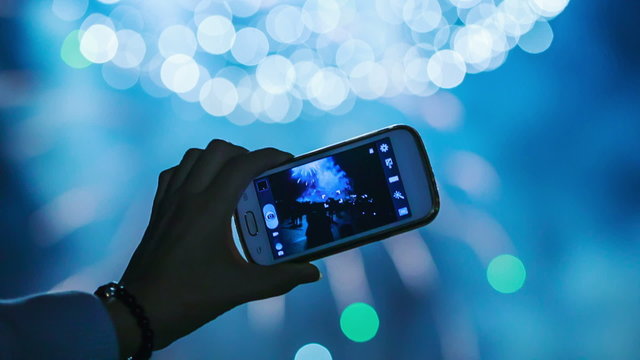 Filming beautiful festive fireworks on smartphone.