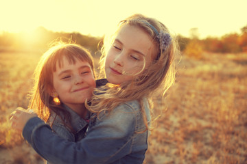 two girls running around the sunny field