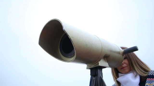 Travel and tourism. Woman looking through the tourist binoculars