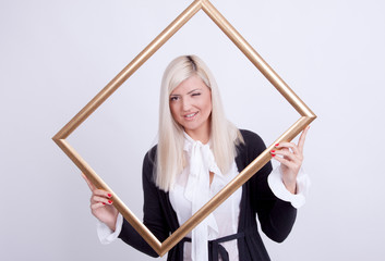 Portrait of a young blond woman holding a frame