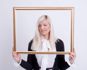 Portrait of a young blond woman holding a frame