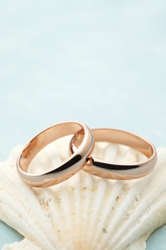 Rose gold wedding rings on seashell