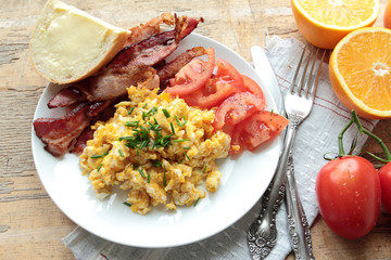Scrambled eggs with tasty bacon and tomatoes