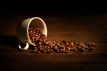 tasse avec des grains de café renversés